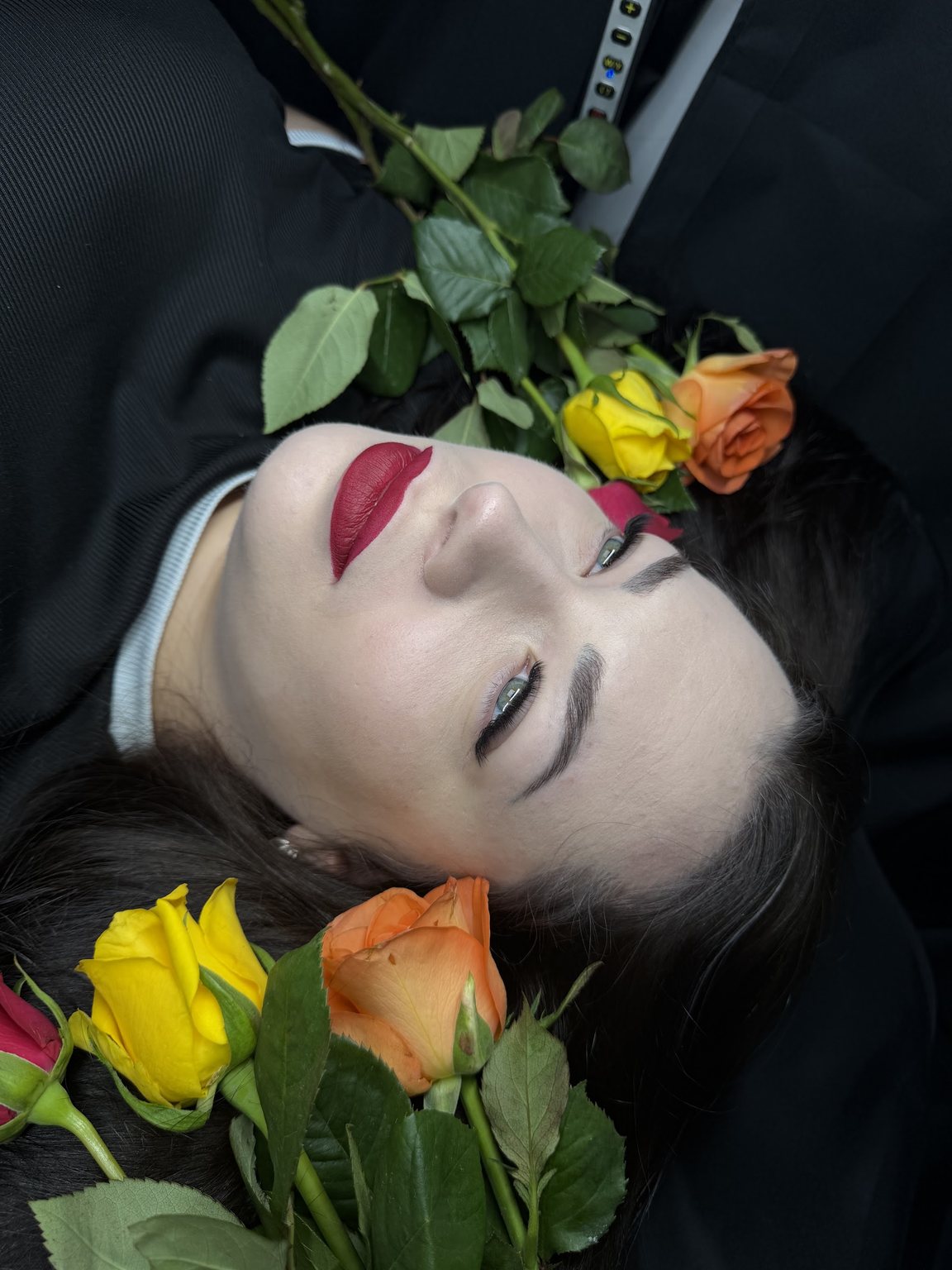 A styled shot of a finished lash set with roses around the client