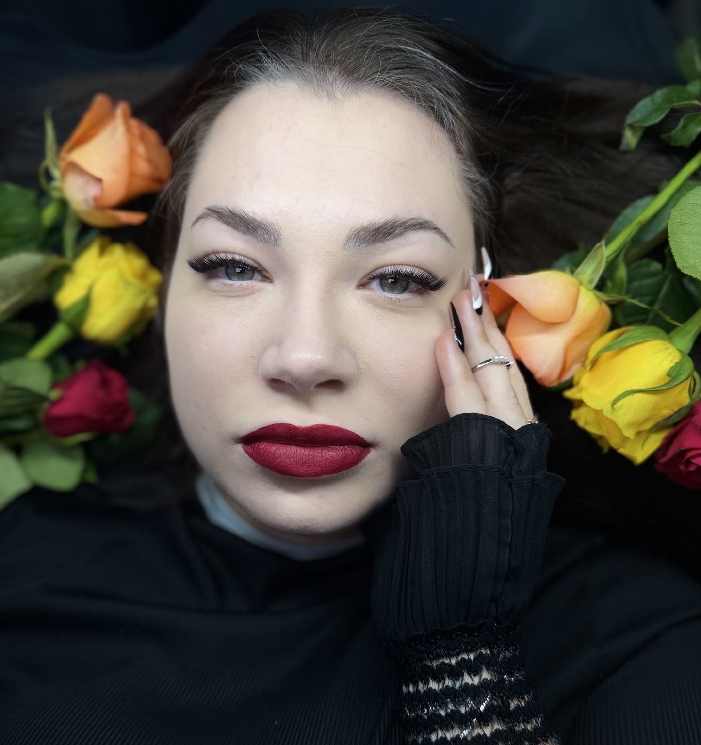 Anett’s Bridgerton-themed competition set: a model framed by roses, red lip, dramatic lashes