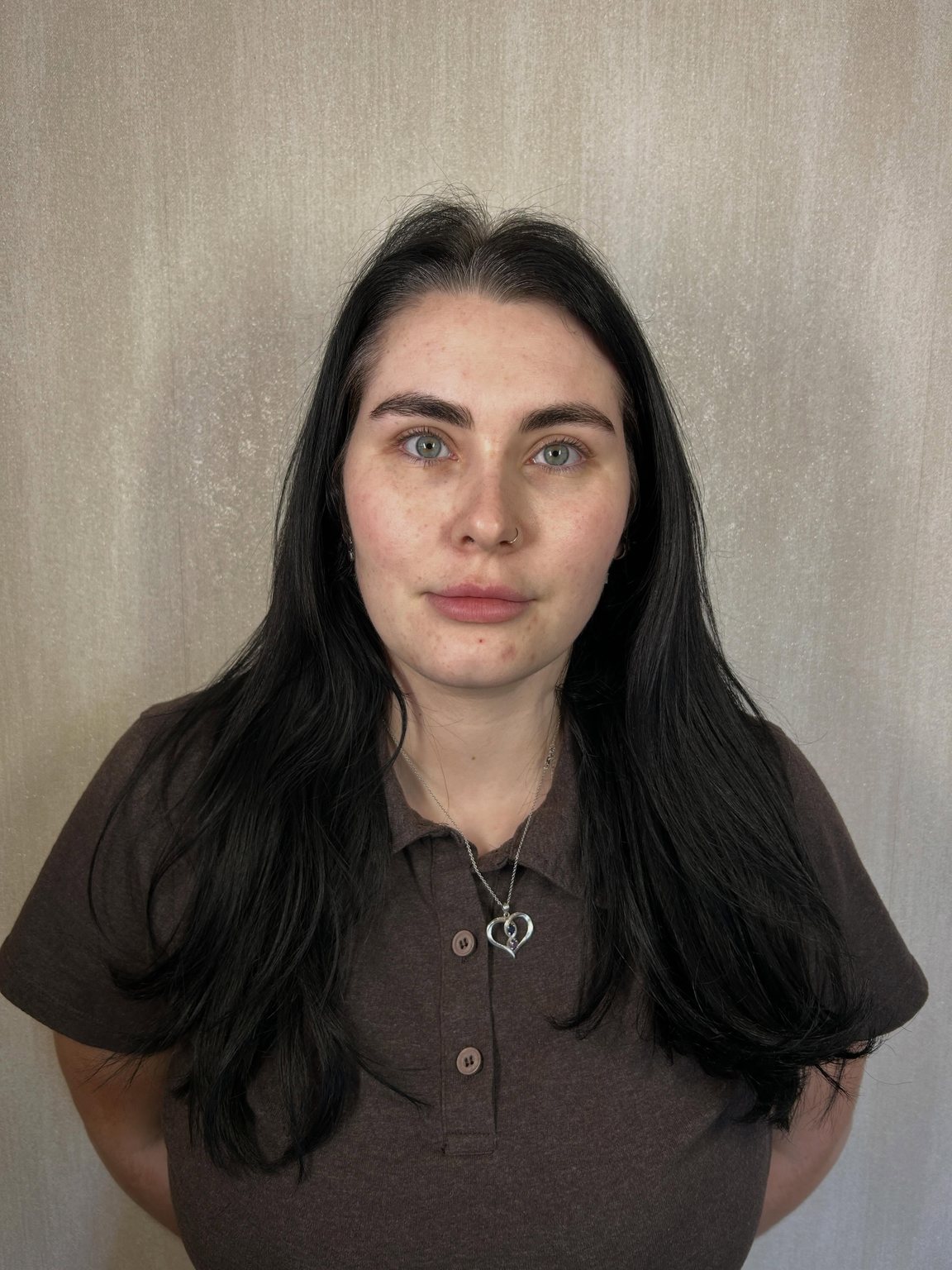 A client standing against a plain wall after her appointment